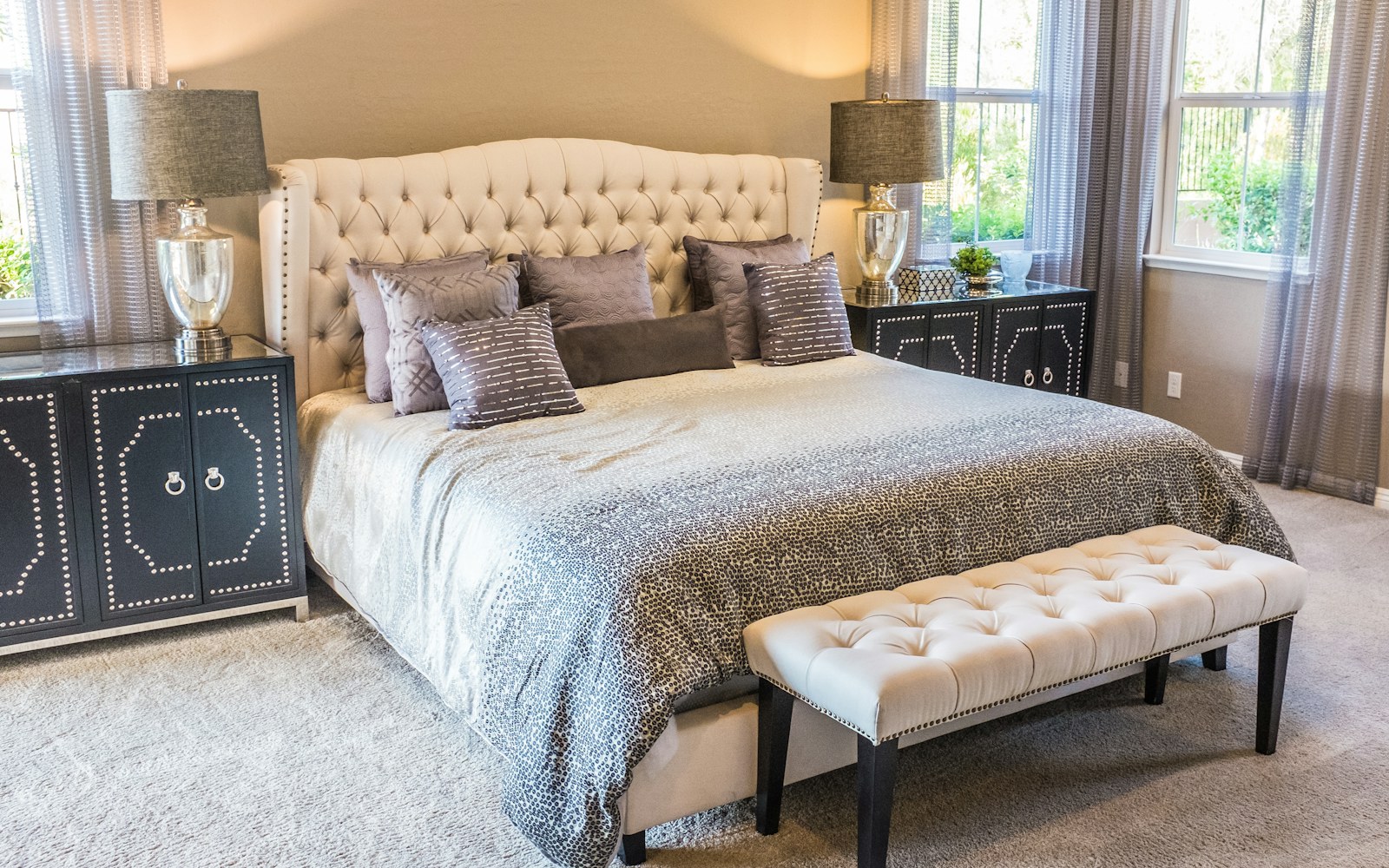 A light, inviting bed dressed in breathable neutral sheets