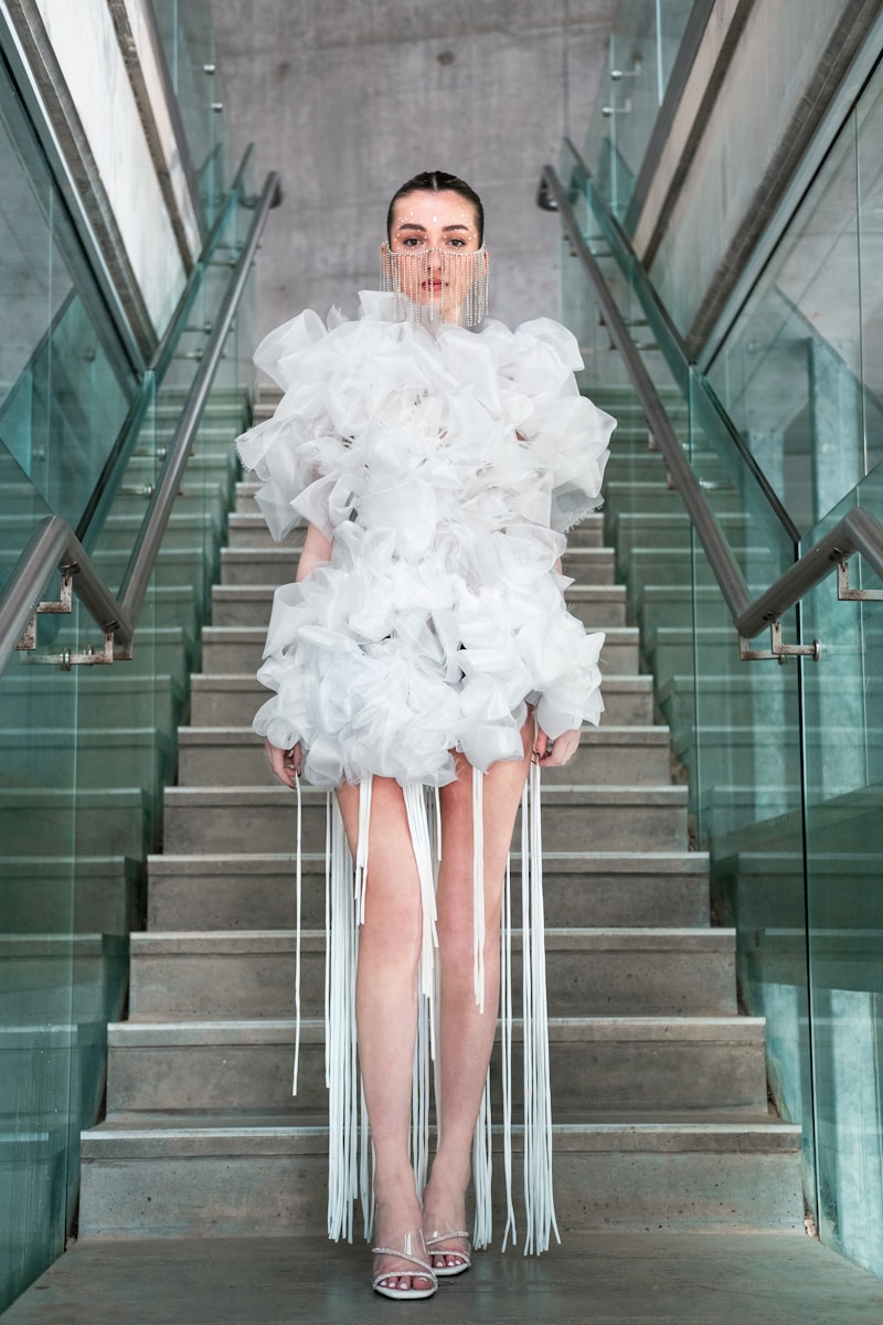 a woman in a white dress standing on a staircase