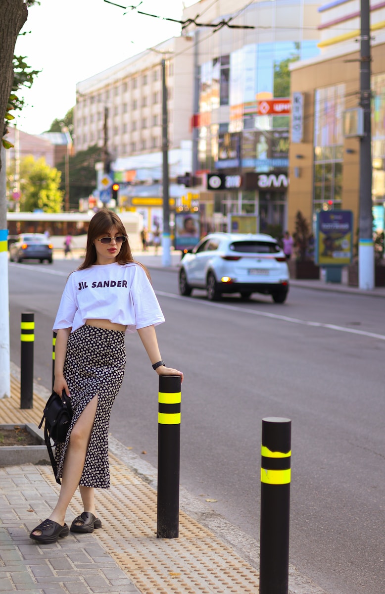 a woman standing on the side of a street