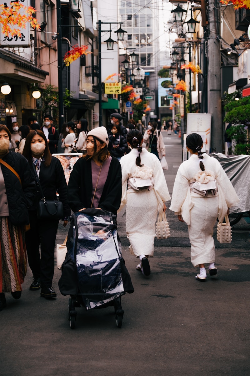 a group of people walking down a street with a person in a garment